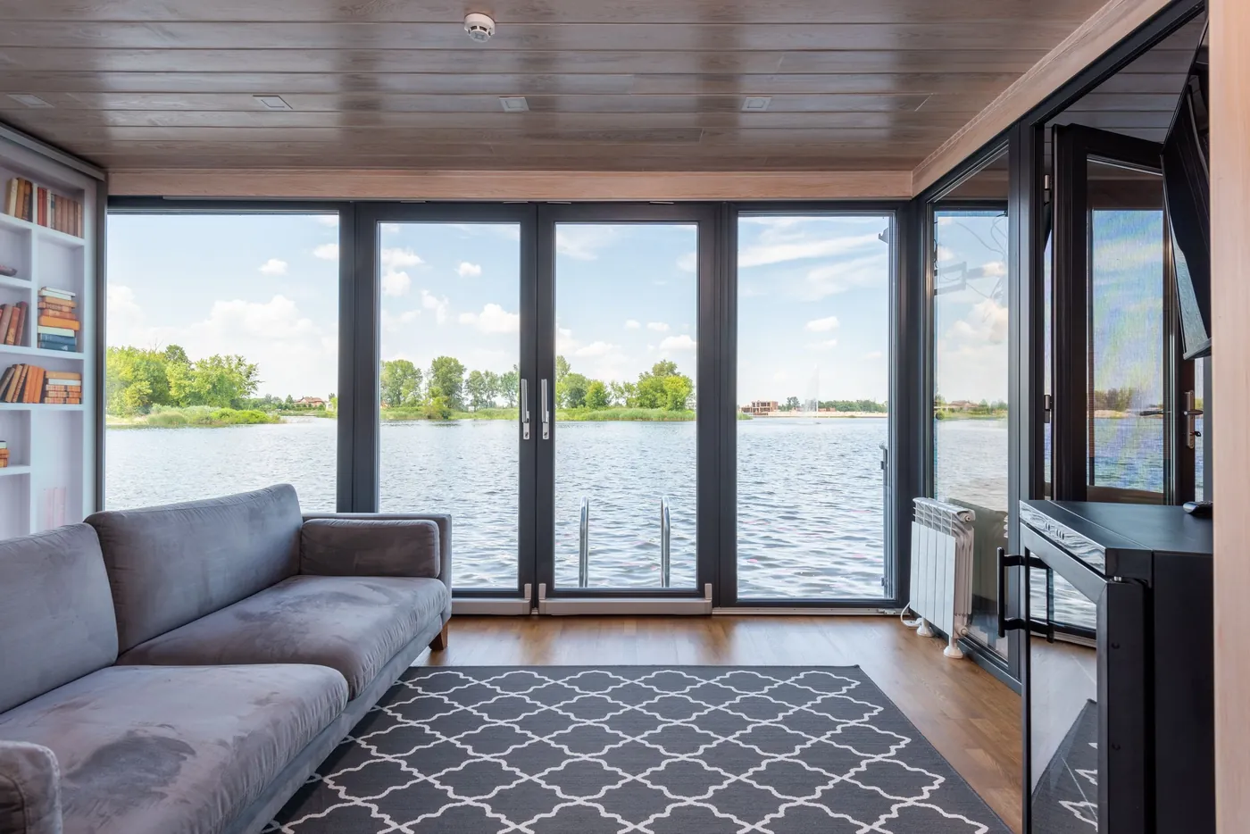 Sala com vidros do piso ao teto e vista ampla, com luz natural controlada